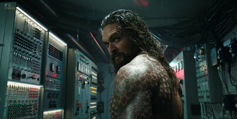 Jason Momoa sebagai Arthur Curry, berdiri di ruang kontrol dan melihat dari balik bahunya di 'Aquaman' (2018)