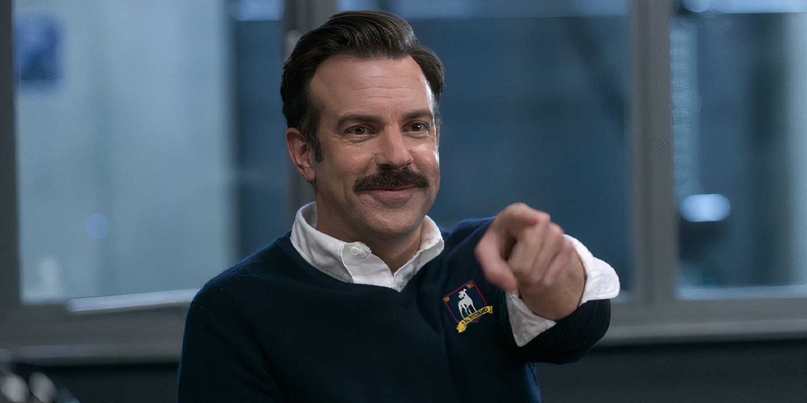 Jason Sudeikis in Ted Lasso Season 2 Episode 1 pointing at the camera while smiling.