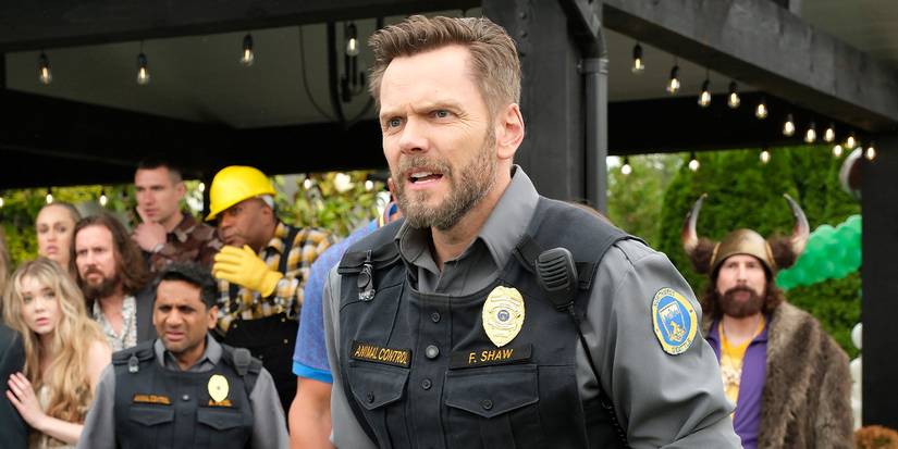 Joel McHale, Frank'in bir üniforma ile durması ve hayvan kontrolünde bir kalabalığın önünde bir yelek.