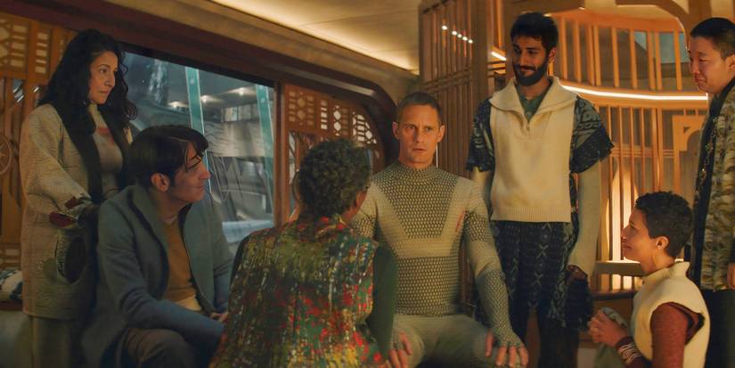The Murderbot cast gathered around a sitting Alexander Skarsgard in Episode 10
