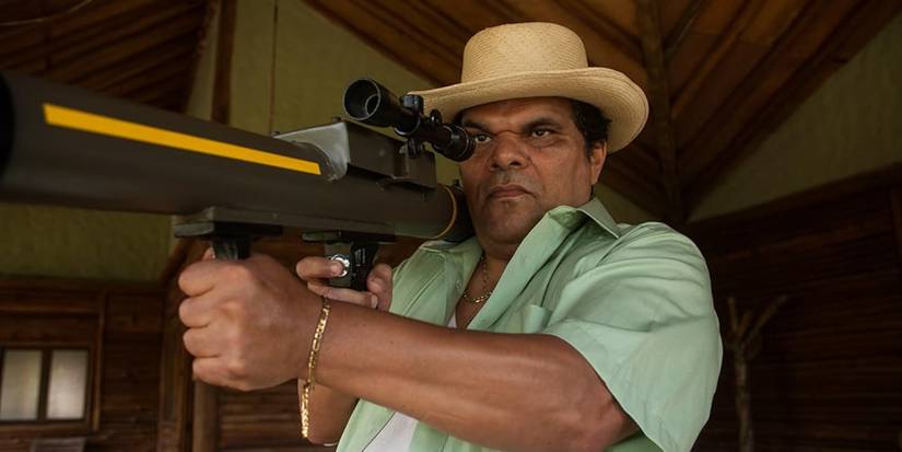 Luis Guzman holding a bazooka and pointing it off screen in Narcos, "Explosivos"