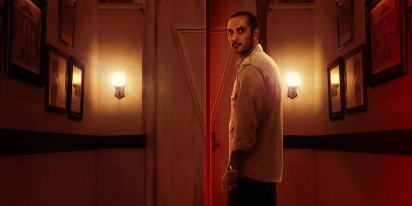 a man in stands in a dimly lit corridor in 'Joko anwar's nightmares and daydreams'