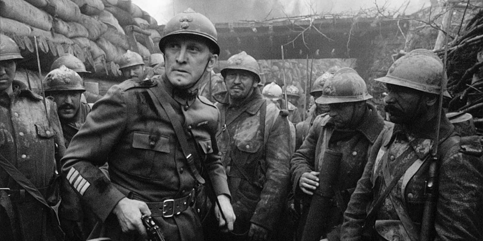 Kirk Douglas holding a gun while standing in a trench near the beginning of Paths of Glory (1957).