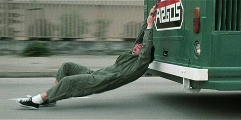 Jackie Chan hanging off a bus traveling at high speeds in Police Story (1985)