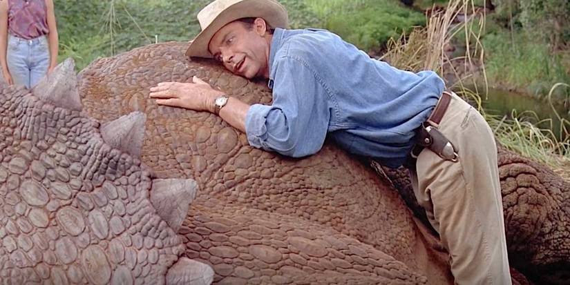 Dr. Alan Grant (Sam Neill) lies on a Triceratops in Jurassic Park.