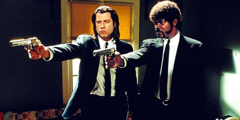 John Travolta and Samuel L. Jackson as Vincent Vega and Jules Winnfield wearing black suits and holding a gun in 'Pulp Fiction'