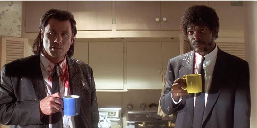 John Travolta and Samuel L. Jackson as Vincent Vega and Jules Winnfield wearing black suits and drinking coffee in 'Pulp fiction'