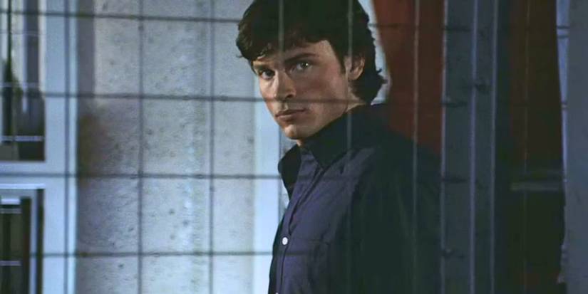 Tom Welling as Clark Kent looking intently to the side through a barred window in Smallville.