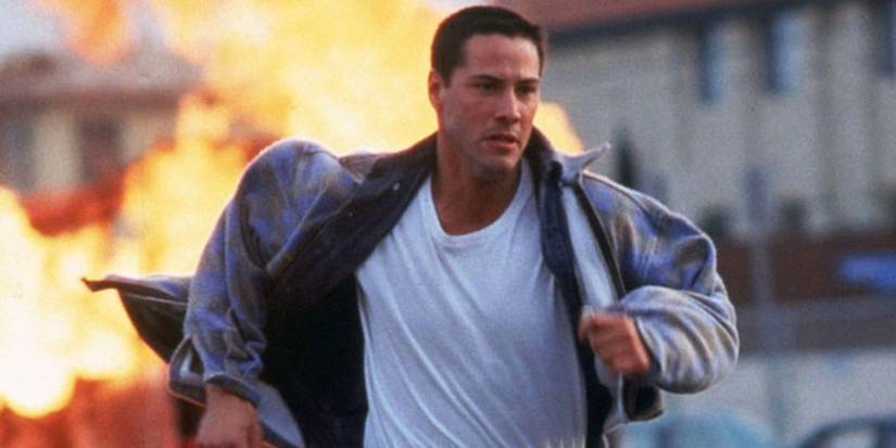 Keanu Reeves running away with fire in the background in Speed (1994)