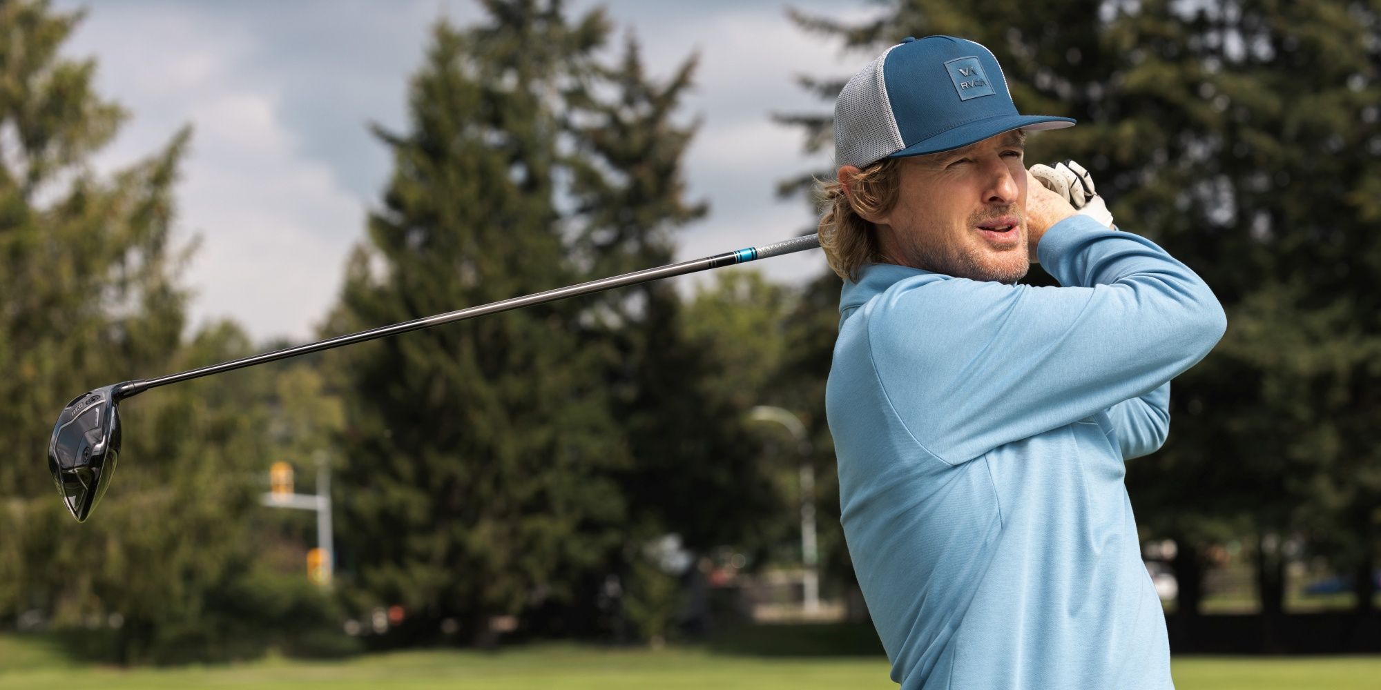 Owen Wilson as Pryce swinging a golf club behind his shoulder while on a course in Apple TV+'s Stick