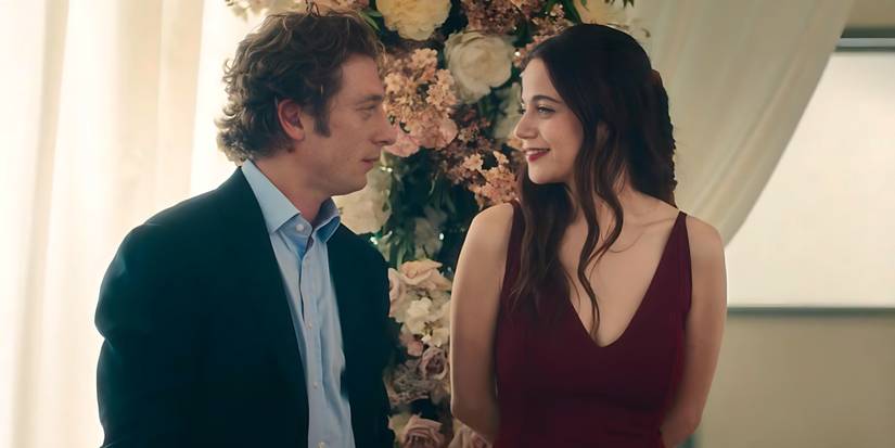 Carmy (Jeremy Allen White) and Claire (Molly Gordon) smiling at each other at a wedding in The Bear.