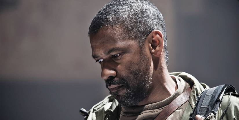 Denzel Washington looking down at something in The Book of Eli