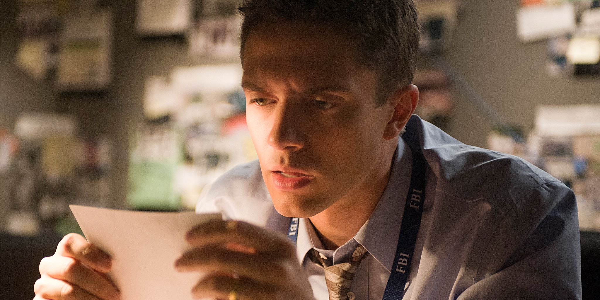 Topher Grace analysing a piece of paper in his FBI office in The Double