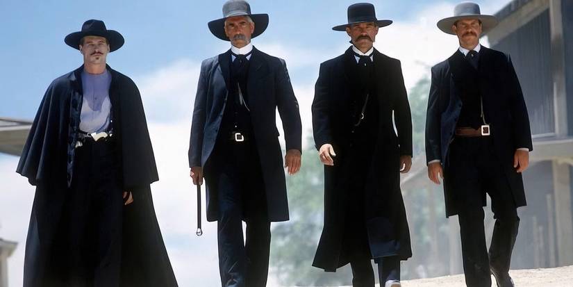 Doc Holliday, Virgil Earp, Wyatt Earp, and Morgan Earp walk side by side in Tombstone.