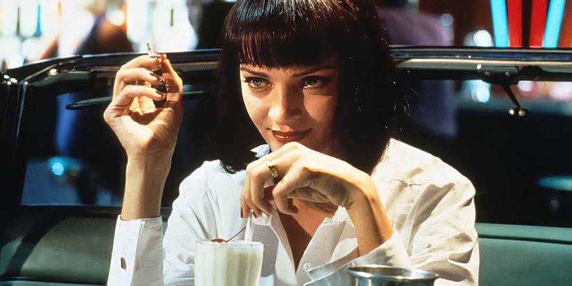 Mia Wallace with a confident smile while smoking and drinking a milkshake in Pulp Fiction