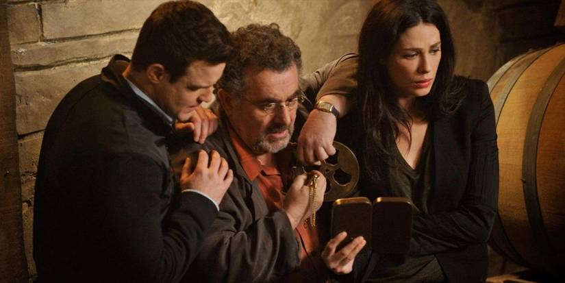 Pete Lattimer (Eddie McClintock), Artie Nielson (Saul Rubinek), and Myka Bering (Joanne Kelly) look at the Farnsworth on 'Warehouse 13'