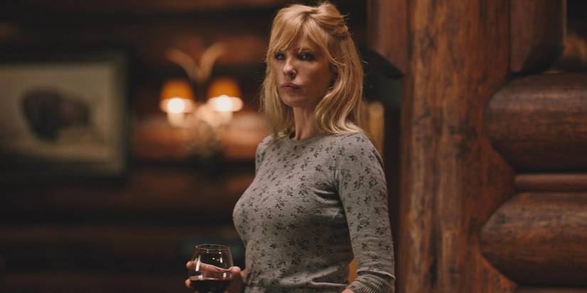 Beth holding a glass of whiskey and looking sad in Yellowstone, No Such Thing as Fair.