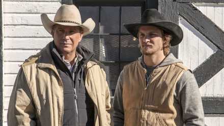 Kevin Costner and Luke Grimes standing in front of a barn in Yellowstone, Coming Home.