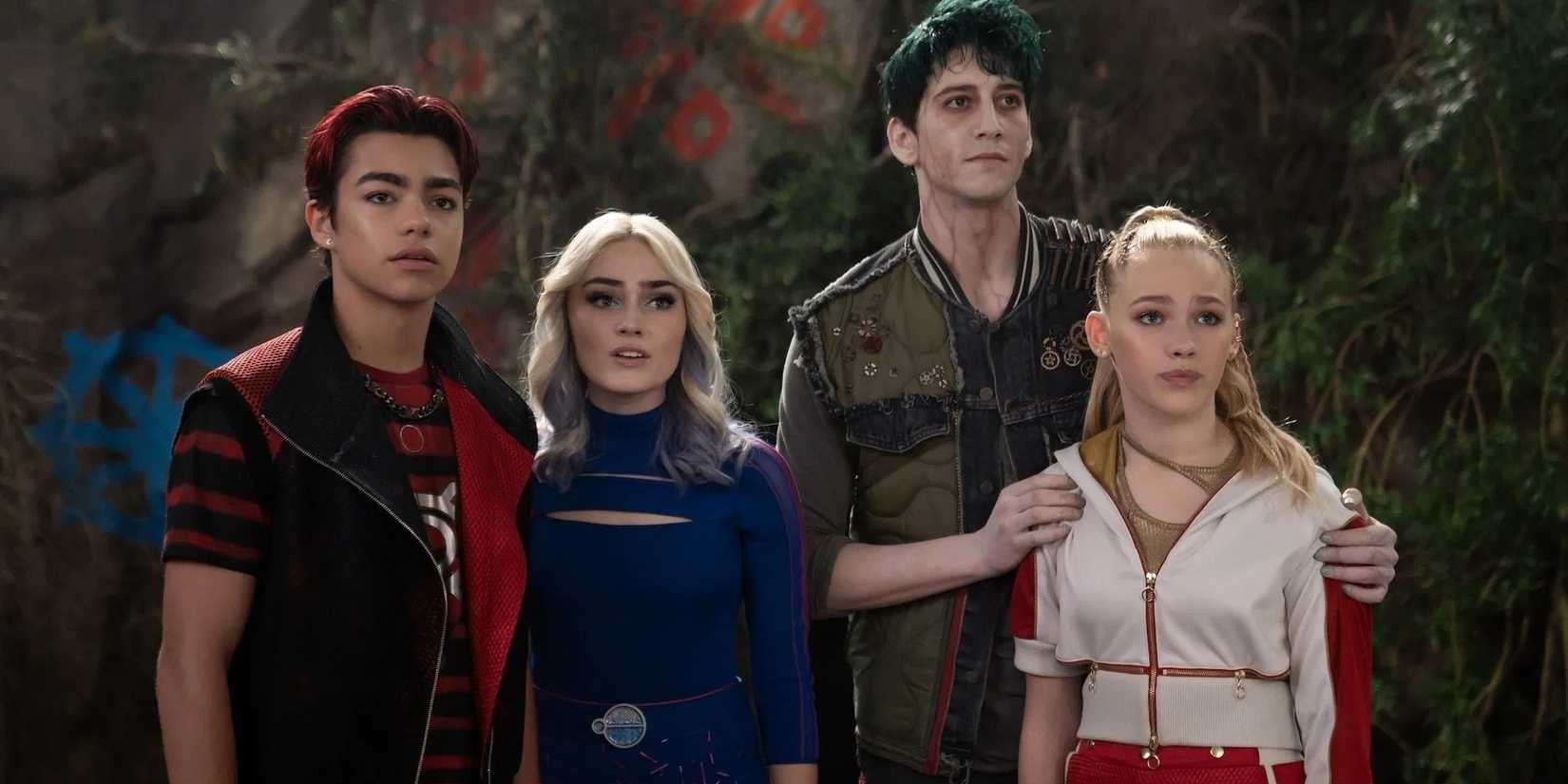 Victor, Addison, Zed and Nova, played by actors Malachi Barton, Meg Donnelly, Milo Manheim and Freya Skye, stand in a row looking at something off-screen in Zombies 4: Dawn of the Vampires.