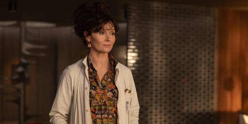 Dame Sylvia (Essie Davis) in a white lab coat looking to the side in Alien: Earth.
