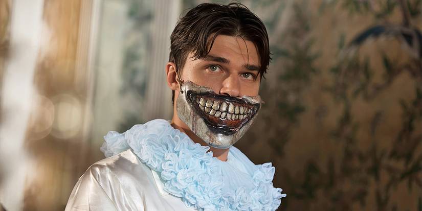 Finn Wittrock as Dandy in AHS Freak Show wearing Twisty the Clown's scary smile half-mask