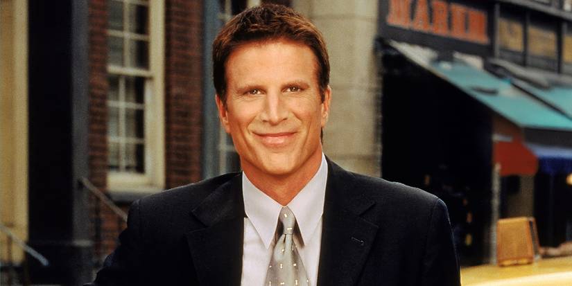 Ted Danson in a suit and tie smiling and looking at the camera as Dr. Becker in Becker.