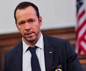 Donnie Wahlberg as Danny Reagan in Blue Bloods stands in a suit during a court hearing