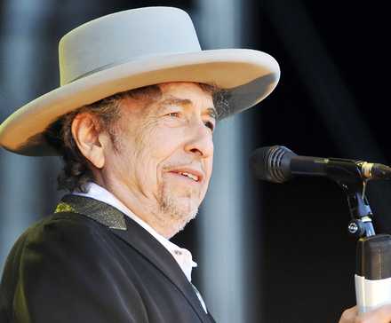 Bob Dylan onstage in front of a microphone.