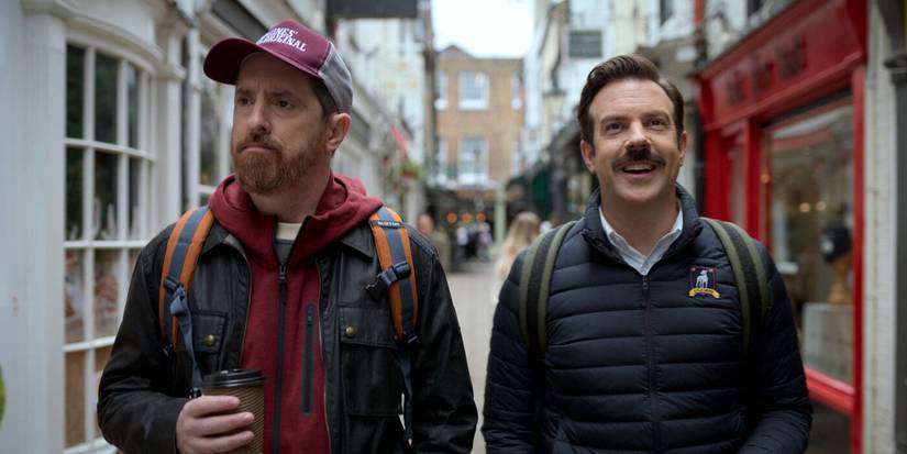 Coach Beard and Ted Lasso walk down a narrow street pensively in Ted Lasso, season 2, episode 5, Rainbow.