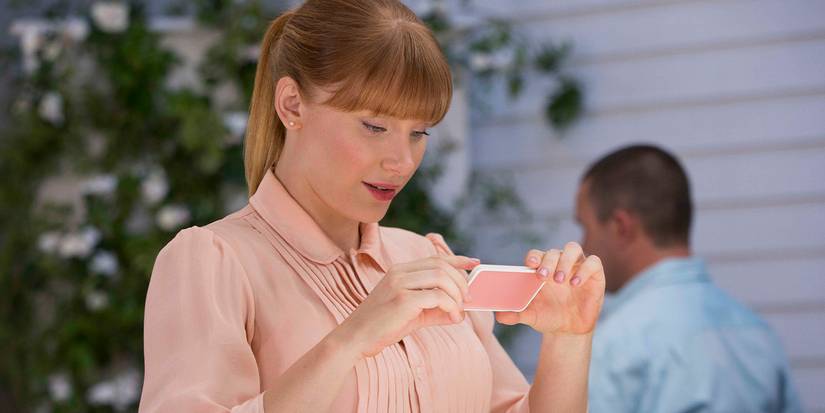 Bryce Dallas Howard staring at a small device in Nosedive episode of Black Mirror.
