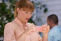 Bryce Dallas Howard staring at a small device in Nosedive episode of Black Mirror.