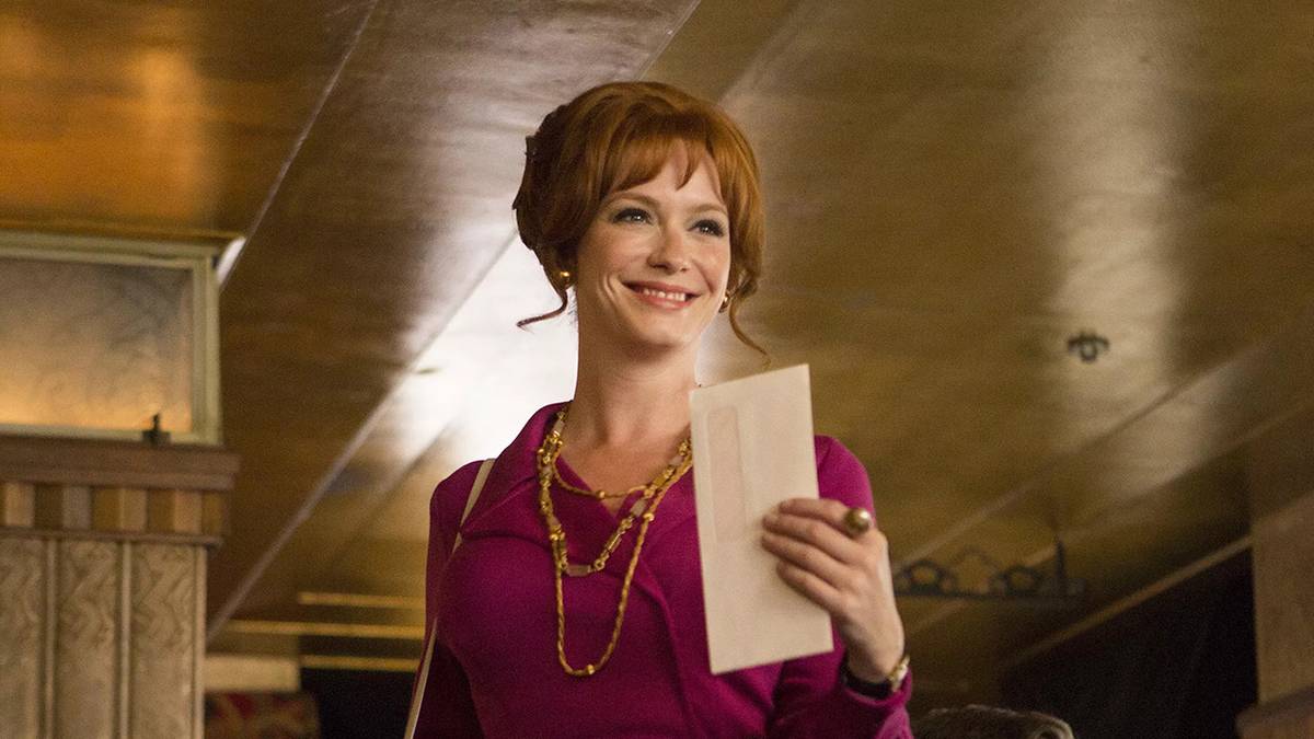 Christina Hendricks as Joan Harris (née Holloway) holding an envelope in the office from Mad Men.