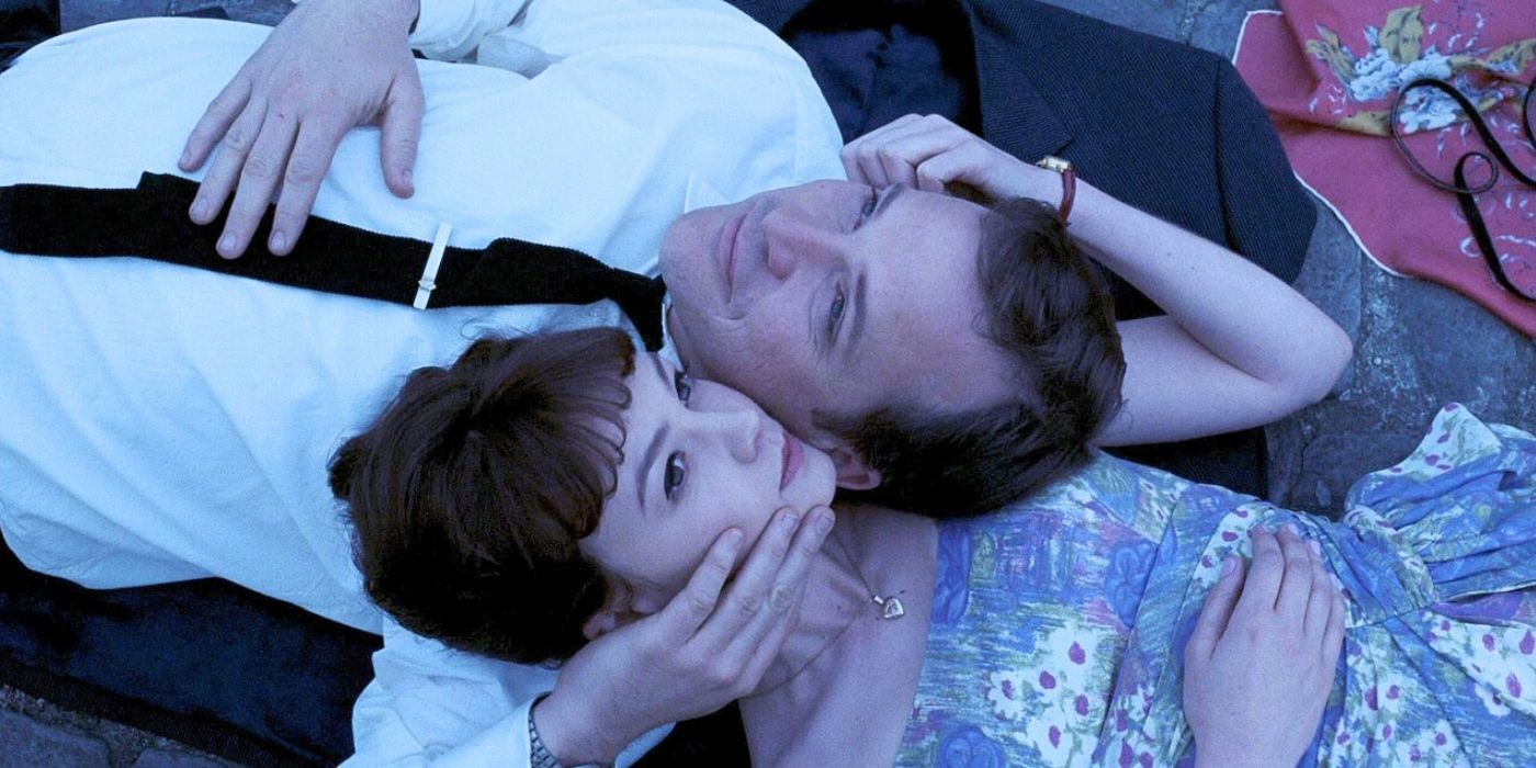 David and Jenny lie with their faces pressed together in a makeshift picnic in Paris in An Education