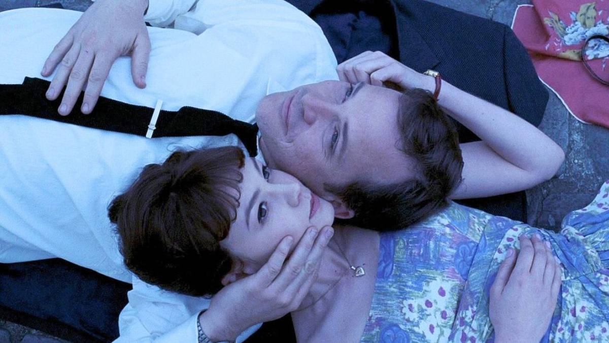 David and Jenny lie with their faces pressed together in a makeshift picnic in Paris in An Education