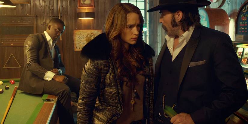 Dolls (Shamier Anderson) sits on a pool table and looks on at Wynonna and Doc on Wynonna Earp