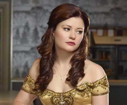 Emilie de Ravin as Belle in a yellow dress, looking wistfully to the side in Once Upon a Time.