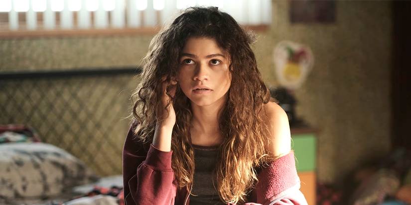 Zendaya as Rue sitting on a bed in Euphoria.