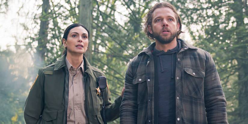 Morena Baccarin as Mickey Fox standing with Max Thieriot as Bode Leone in the woods in Fire Country