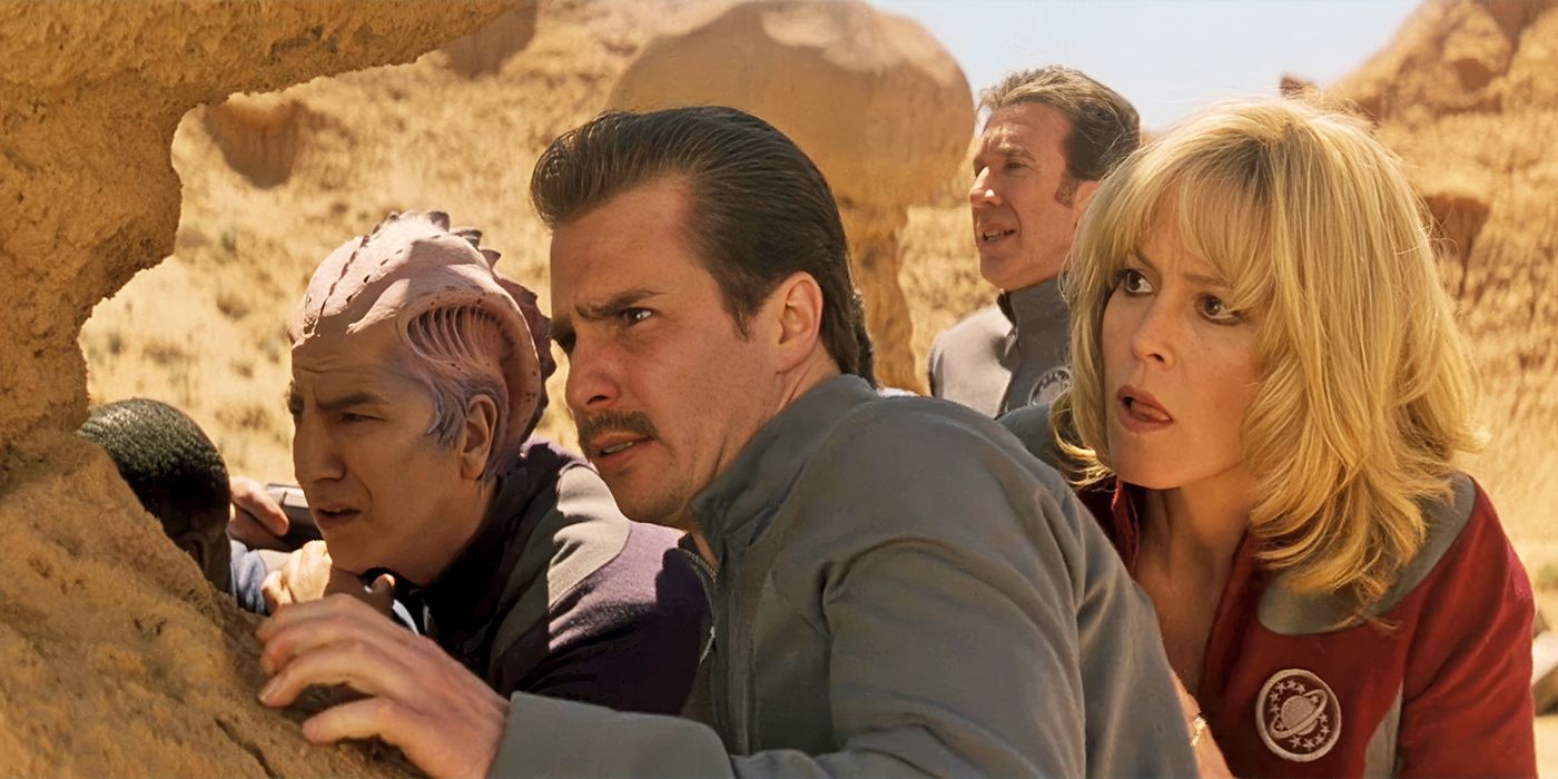 The Galaxy Quest crew hides behind rocks in the desert