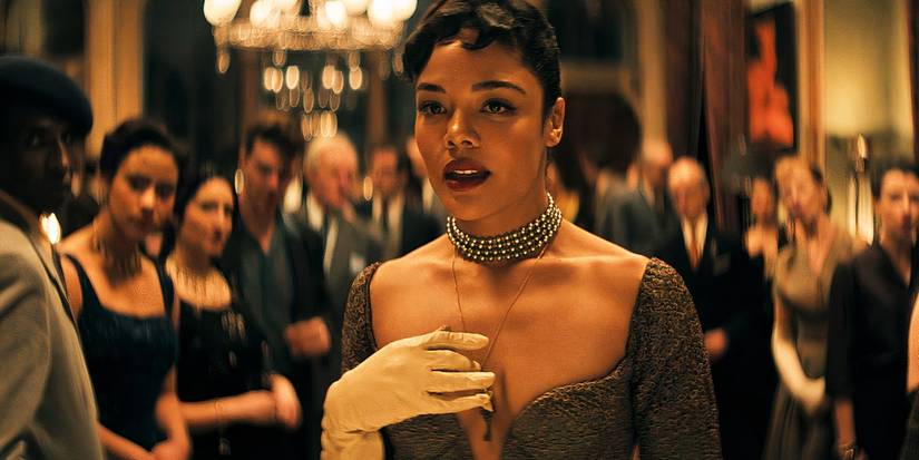 Tessa Thompson wears an ornate gown and looks off camera in Hedda