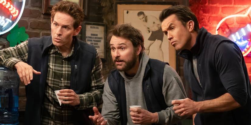 Glenn Howerton, Charlie Day, and Rob Mac hold cups and look ahead in It's Always Sunny in Philadelphia.