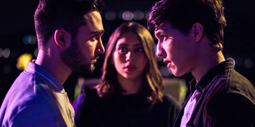 Salma Malhas and two guys staring at each other under purple light in Jinn.