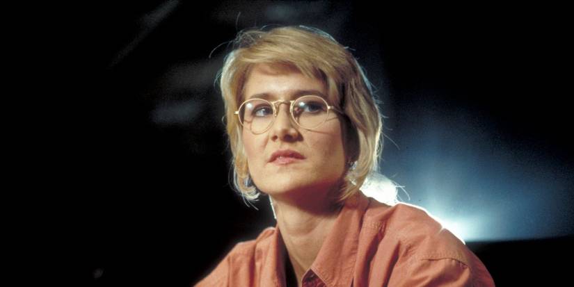 Ellie Sattler (Laura Dern) looks off into the distance while lit from behind in Jurassic Park.