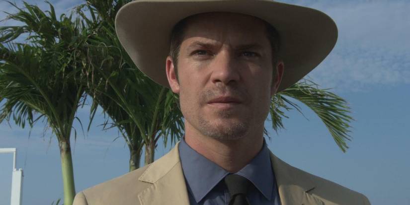 Timothy Olyphant wearing a hat with palm trees behind in the Justified pilot Fire in the Hole.