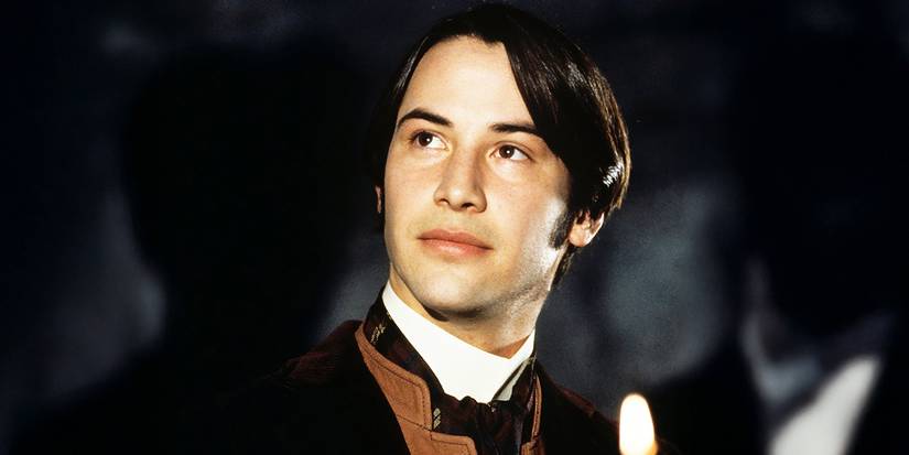 Keanu Reeves looking at something with a smile on his face in Dracula