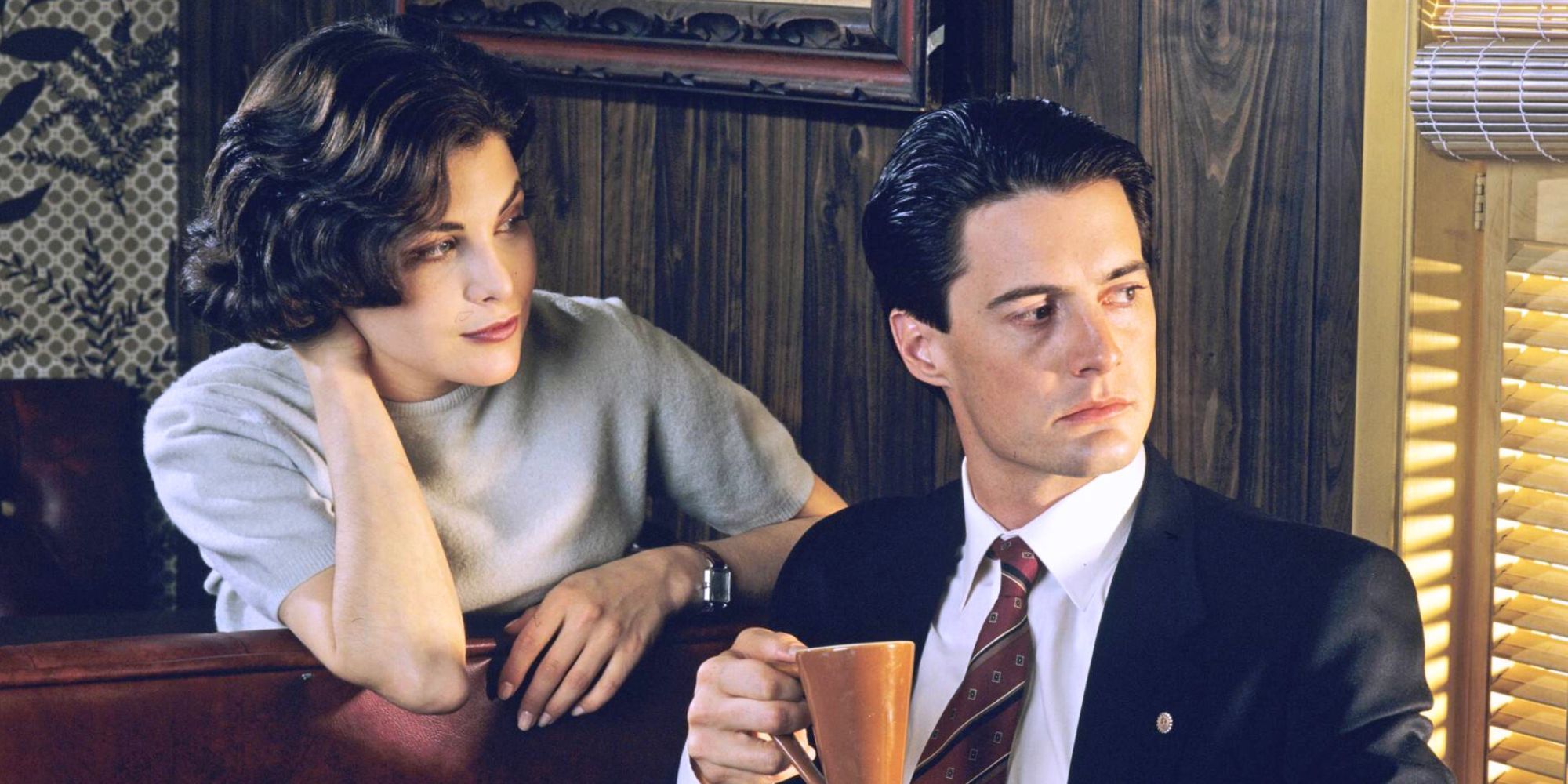Kyle MacLachlan and Sherilyn Fenn at a booth in a diner looking out a window in Twin Peaks.