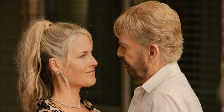 Ali Larter and Billy Bob Thornton standing close together and smiling at each other in Landman.