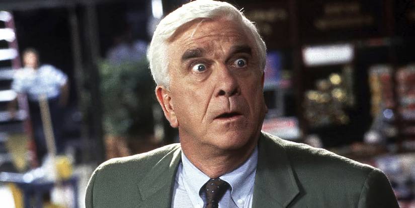 Leslie Neilsen as Frank Drebin in The Naked Gun, staring off-camera and looking shocked.