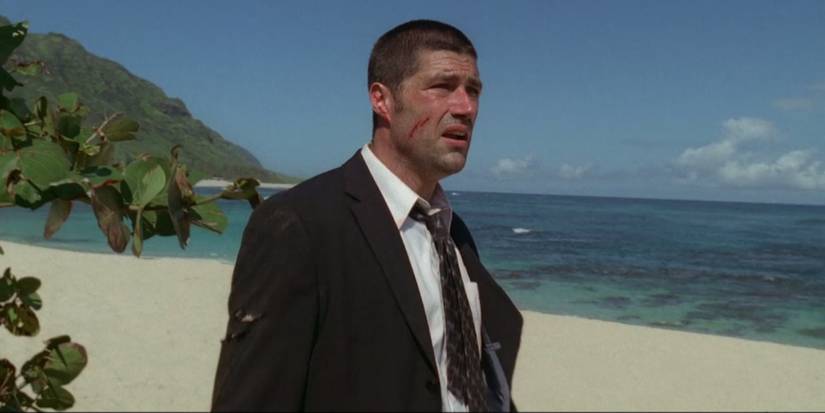 Jack looking out in despair while standing on a beach in the pilot episode of Lost (2004).