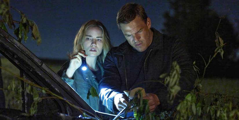 Reacher and another person holding a flashlight investigate something outside at night in Reacher.